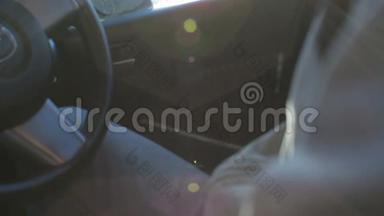 男司机在阳光下坐在车里。 太阳光束方向盘
